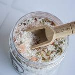 Słoik z solą do pielęgnacji ciała i drewnianą łyżeczką skinergy